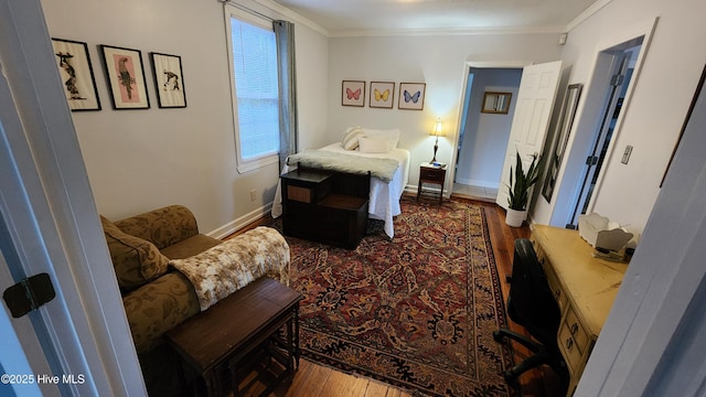 bedroom with ornamental molding, baseboards, and dark wood finished floors