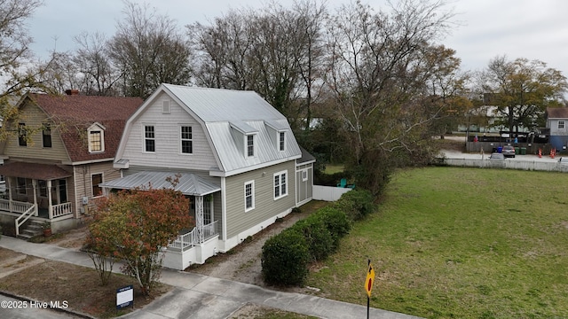 view of side of home with a gambrel roof and a yard