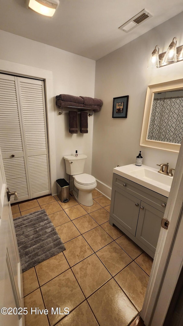 bathroom featuring visible vents, toilet, tile patterned flooring, and vanity