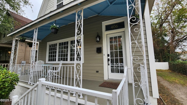 entrance to property with fence and a porch