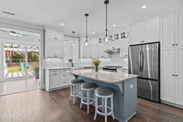 114 Sundance Cir, Hampstead, NC 28443 - kitchen with appliances with stainless steel finishes, under cabinet range hood, white cabinetry, dark wood-style flooring, and a breakfast bar area