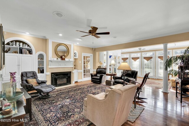 living area with a ceiling fan, crown molding, stairway, and wood finished floors