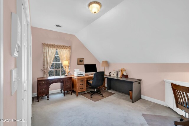 home office featuring baseboards, lofted ceiling, light colored carpet, and visible vents