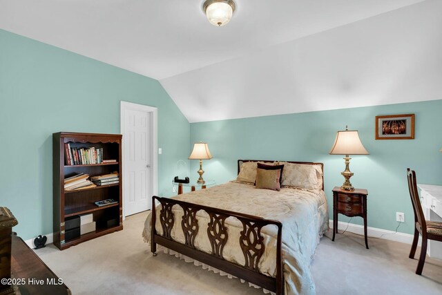 carpeted bedroom with baseboards, visible vents, and vaulted ceiling