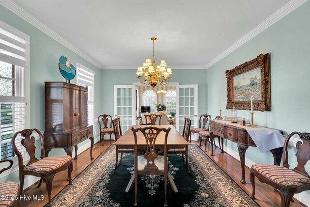 dining space featuring plenty of natural light, stairs, wood finished floors, and a chandelier
