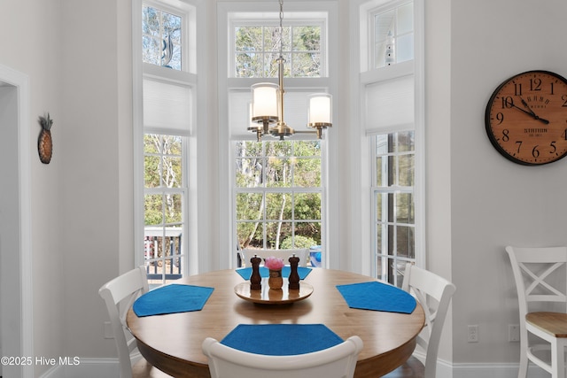 dining area featuring baseboards and a notable chandelier
