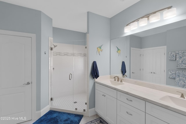 bathroom with double vanity, a sink, tile patterned floors, and a shower stall