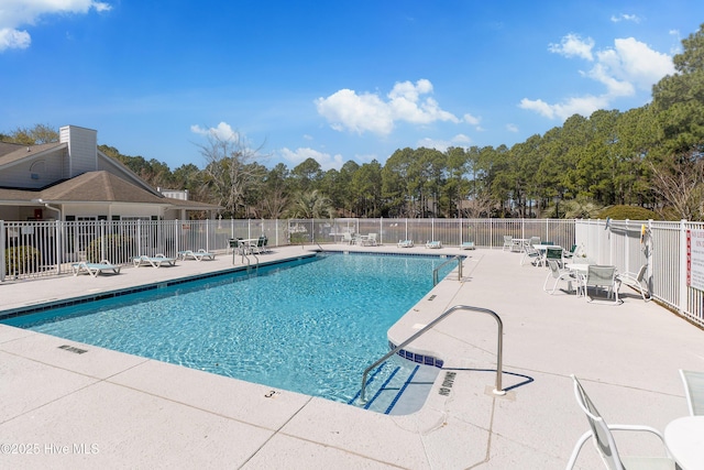community pool with fence and a patio