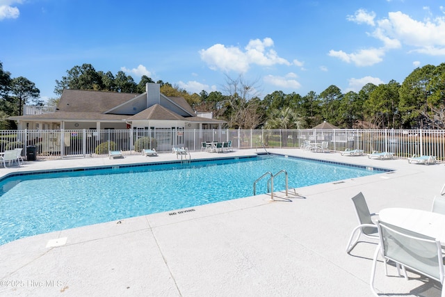 community pool featuring fence and a patio