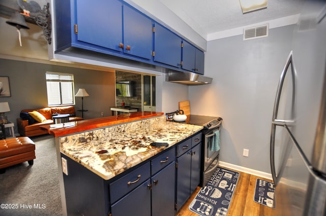 10170 Beach Dr SW Unit 305, Calabash, NC 28467 - kitchen with blue cabinetry, appliances with stainless steel finishes, a peninsula, under cabinet range hood, and wood finished floors
