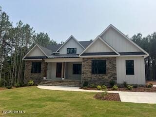 130 Gails Rd, West End, NC 27376 - view of front of property featuring covered porch, a front lawn, and stone siding