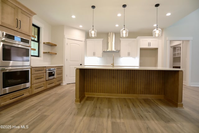 130 Gails Rd, West End, NC 27376 - kitchen with wall chimney exhaust hood, stainless steel double oven, backsplash, light wood-style flooring, and recessed lighting