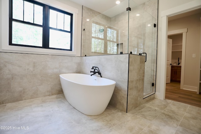 130 Gails Rd, West End, NC 27376 - bathroom featuring a shower stall, a soaking tub, recessed lighting, and tile walls