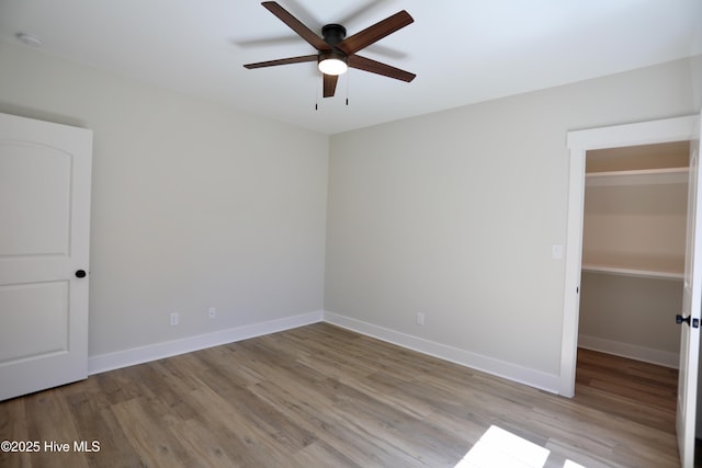 130 Gails Rd, West End, NC 27376 - unfurnished bedroom with wood finished floors, a spacious closet, and ceiling fan