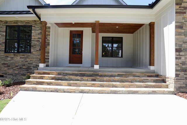 130 Gails Rd, West End, NC 27376 - property entrance featuring board and batten siding, a porch, a standing seam roof, and stone siding