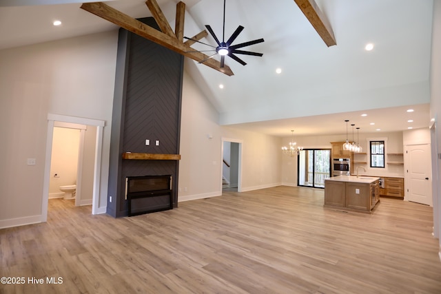 130 Gails Rd, West End, NC 27376 - unfurnished living room with high vaulted ceiling, a chandelier, beam ceiling, stairs, and light wood-type flooring