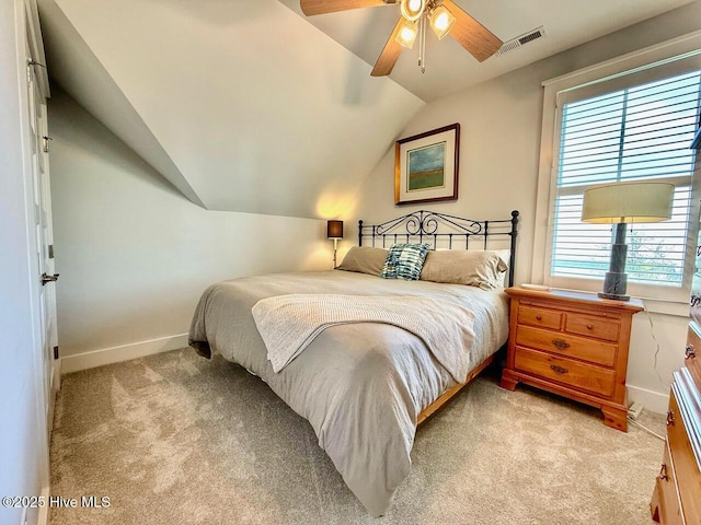 bedroom featuring multiple windows, vaulted ceiling, light colored carpet, and baseboards
