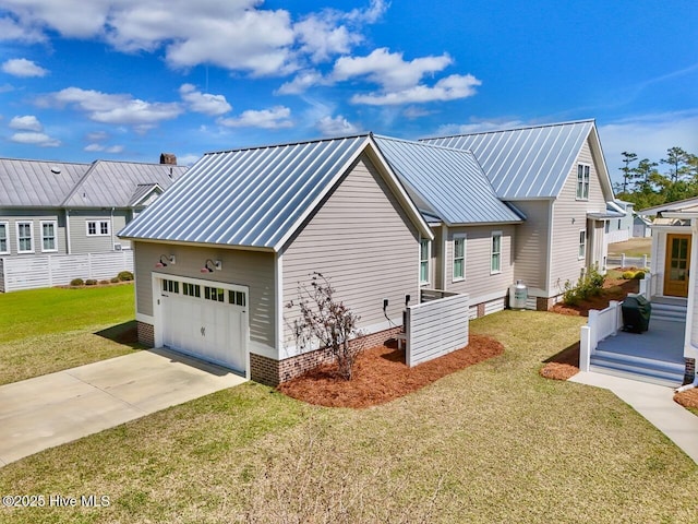 view of side of home with a standing seam roof, metal roof, concrete driveway, and a lawn