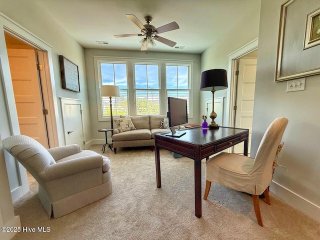interior space featuring light colored carpet, visible vents, a ceiling fan, and baseboards