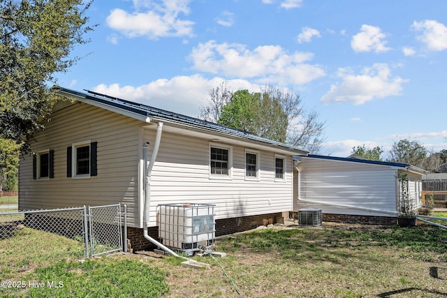 back of house featuring a lawn, fence, and central AC