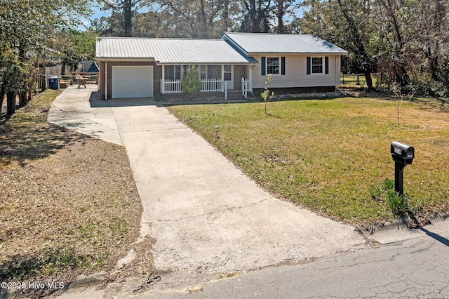 view of front of home with metal roof, fence, an attached garage, concrete driveway, and a front yard