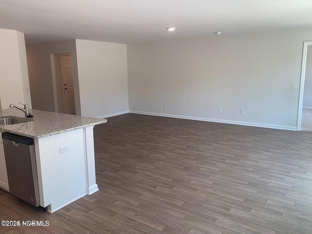 kitchen with dark wood finished floors, a sink, baseboards, and stainless steel dishwasher