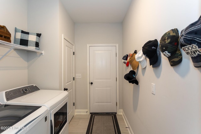 laundry room with baseboards, washer and dryer, and laundry area
