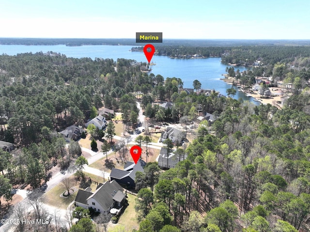 drone / aerial view featuring a water view and a wooded view