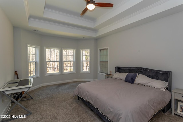 carpeted bedroom with a tray ceiling, baseboards, visible vents, and ornamental molding