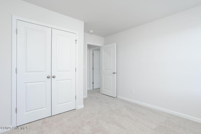 3806 Falcon Ct NW, Wilson, NC 27896 - unfurnished bedroom featuring a closet, baseboards, and light colored carpet