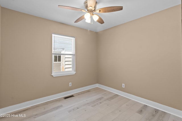 empty room with light wood-style floors, baseboards, ceiling fan, and visible vents