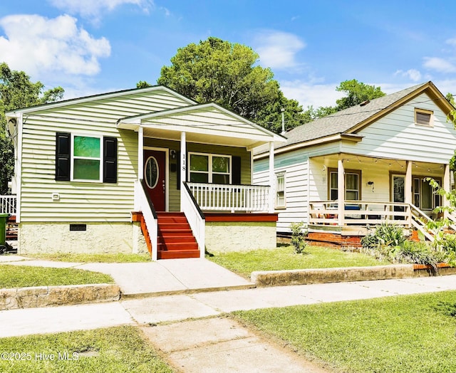 bungalow featuring a porch, a front yard, and crawl space