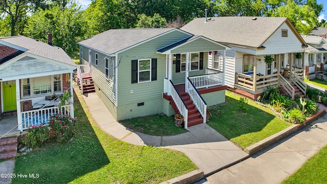 bungalow-style home with covered porch, crawl space, stairway, and a shingled roof