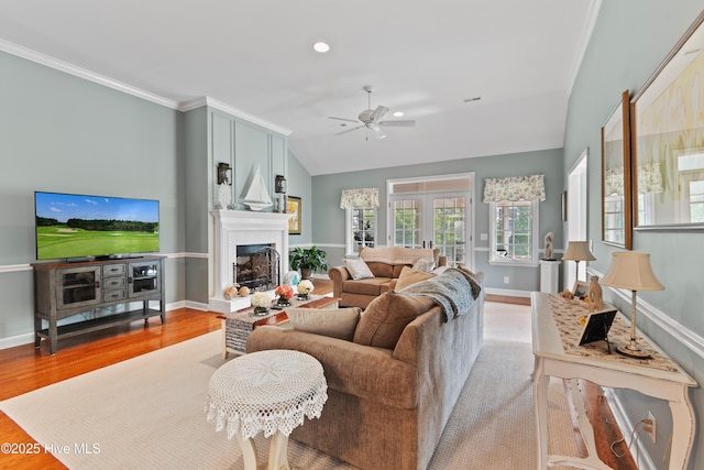 4106 Kittiwake Ct, Southport, NC 28461 - living room featuring ceiling fan, a fireplace, vaulted ceiling, baseboards, and light wood-style flooring