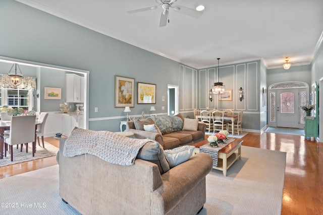 4106 Kittiwake Ct, Southport, NC 28461 - living area featuring a chandelier, ornamental molding, a ceiling fan, wood finished floors, and baseboards
