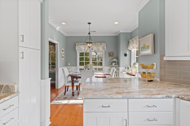 4106 Kittiwake Ct, Southport, NC 28461 - kitchen with crown molding, light wood-type flooring, white cabinetry, a peninsula, and recessed lighting