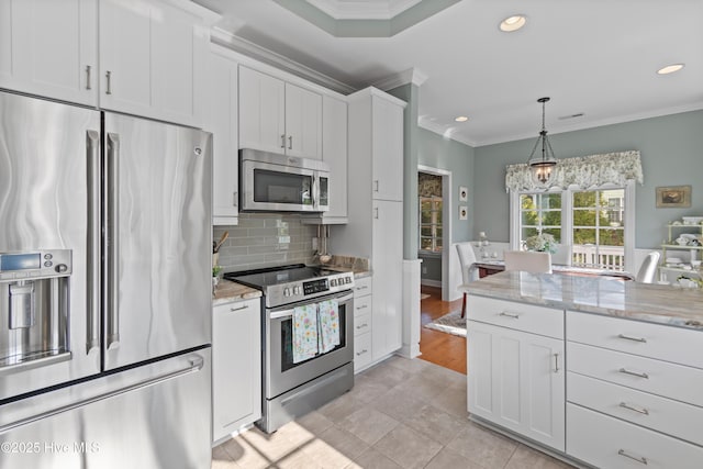 4106 Kittiwake Ct, Southport, NC 28461 - kitchen featuring stainless steel appliances, ornamental molding, white cabinets, tasteful backsplash, and recessed lighting