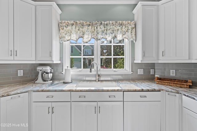 4106 Kittiwake Ct, Southport, NC 28461 - kitchen with a sink, white cabinetry, decorative backsplash, and light stone counters
