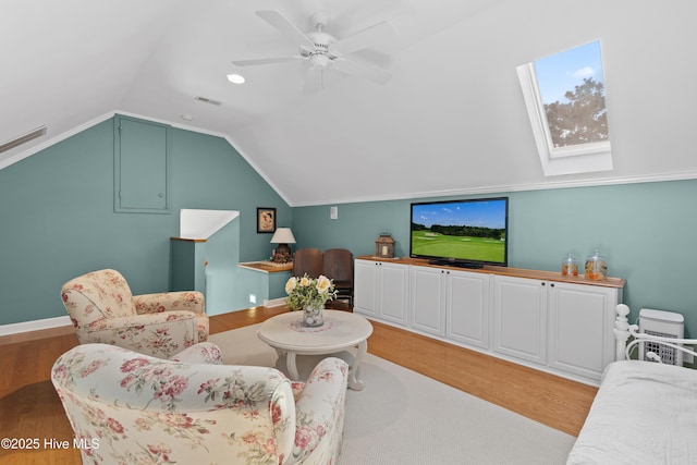 4106 Kittiwake Ct, Southport, NC 28461 - living room with light wood finished floors, vaulted ceiling, ceiling fan, and a skylight