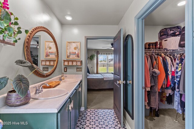 full bath featuring a sink, ensuite bathroom, a walk in closet, and double vanity