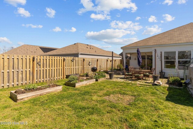 back of property featuring a yard, a fenced backyard, and a patio
