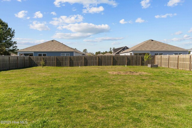 view of yard featuring a patio, fence, and a vegetable garden