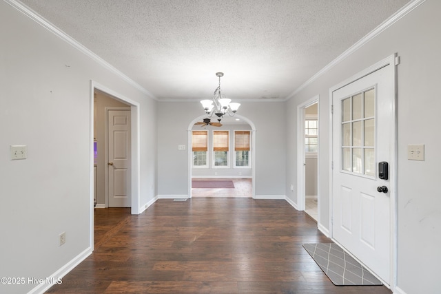 foyer entrance featuring ornamental molding, wood finished floors, and a chandelier