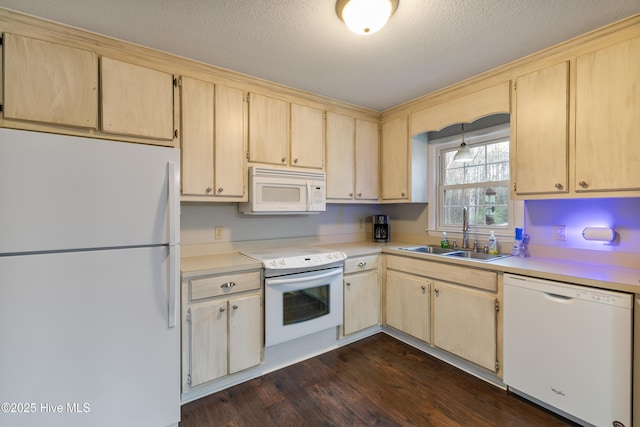 kitchen featuring white appliances, light brown cabinetry, light countertops, and a sink