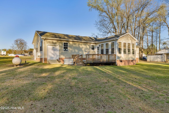 rear view of property featuring crawl space, a deck, and a lawn