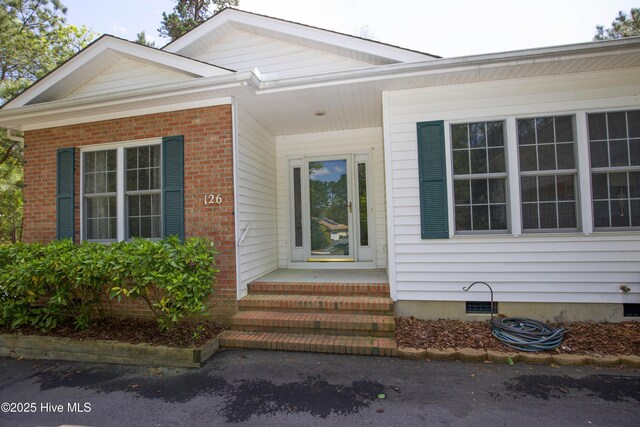 entrance to property featuring brick siding