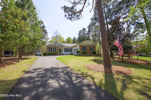 view of front of home with a front lawn, a garage, and aphalt driveway