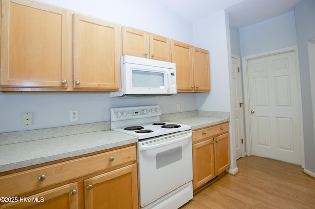 kitchen with white appliances, light brown cabinets, light countertops, and light wood finished floors