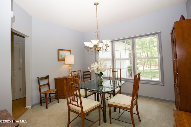 dining area with light colored carpet, baseboards, an inviting chandelier, and a wealth of natural light