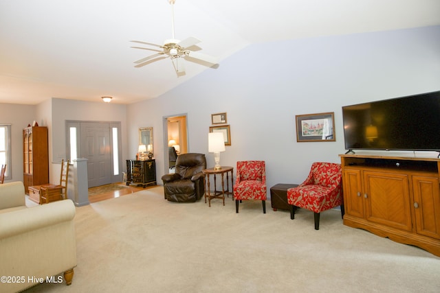 living area with light colored carpet, ceiling fan, and vaulted ceiling